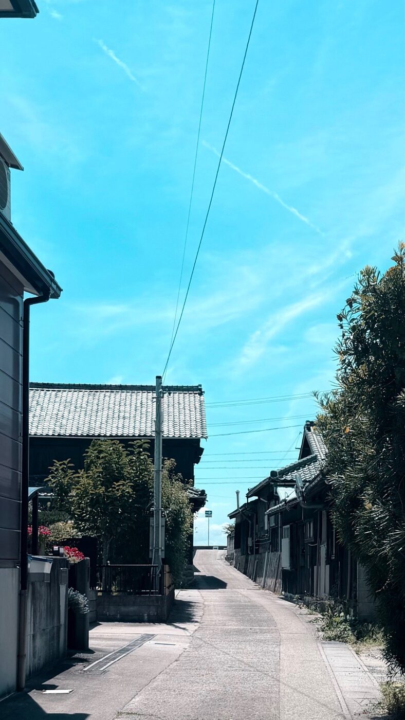 青空の下、海へ抜ける路地